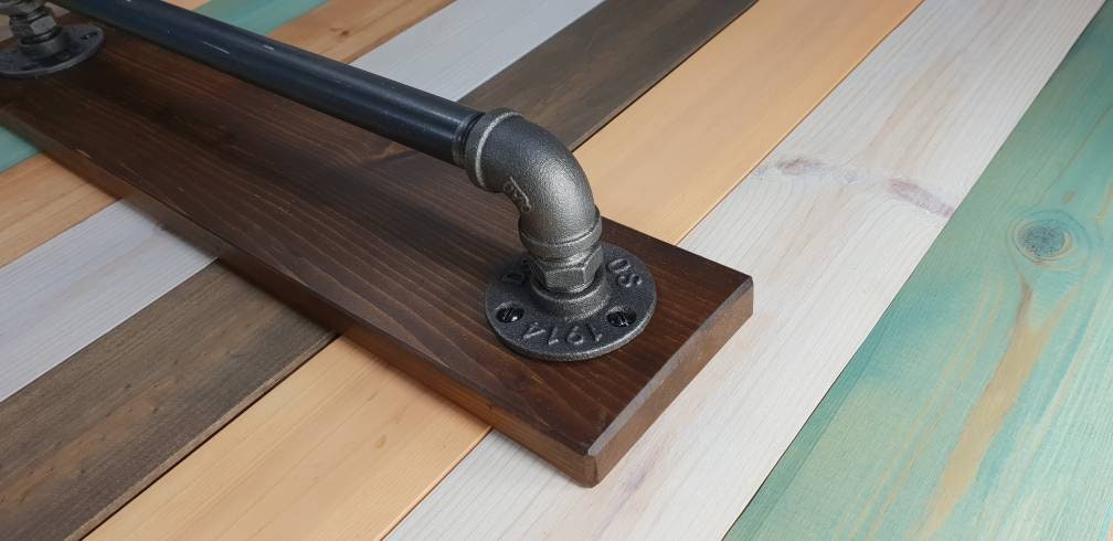 a set : a single towel rail on a walnut finish backing plate and a toilet roll holder with a walnut finish mini shelf above it