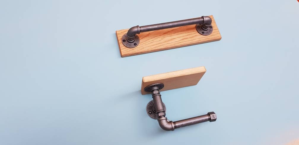 A set of industrial style bathroom fixtures. A gas pipe toilet roll holder with solid oak top and an industrial gas pipe towel rail on a solid oak back plate. contemporary, minimalist, industrial modern bathroom furniture fittings. toilet roll holder and towel rail